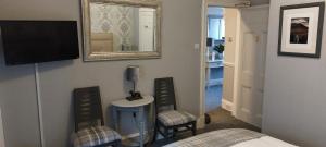 a bedroom with a bed and a television and a mirror at Riverbank Guesthouse Inverness in Inverness