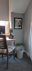 Habitación con escritorio con lámpara y silla. en Riverbank Guesthouse Inverness en Inverness