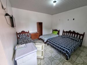 a bedroom with two beds and a tv in it at Suítes em Parintins in Parintins