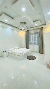 a white room with two beds and a rug on the floor at .Alshorfa _ House. in Qurayyah