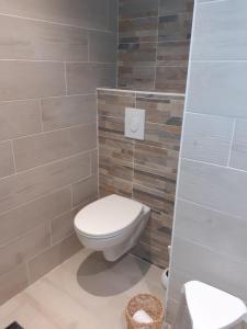 a bathroom with a white toilet in a room at chez le tit in Mèze