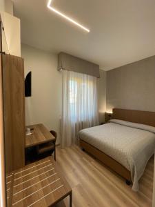 ブレシアにあるVilla Noceのベッドとテーブルが備わるホテルルームです。