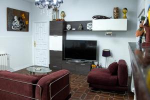 sala de estar con sofá y TV en Casa Cadalso, Mirador de Gredos, Madrid, en Cadalso de los Vidrios