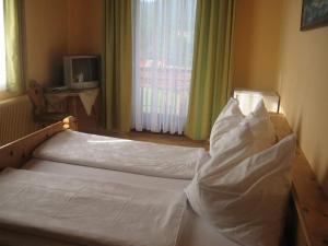 a bedroom with two beds with white sheets and a television at Erholung am Bauernhof bei Familie Seidl / Messner in Zeutschach