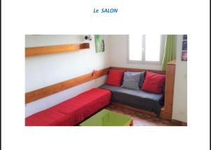 mały salonik z czerwoną i szarą kanapą w obiekcie Appartement terrasse 1 chambre w mieście Porticcio +1 zdjęcie
