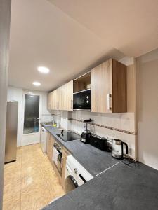 a kitchen with stainless steel appliances and wooden cabinets at Apartamento Zaragoza Centro in Zaragoza