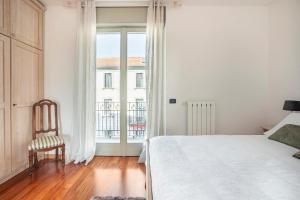 1 dormitorio con 1 cama, 1 silla y 1 ventana en Alma Bergamo - Bilocale vicino alla stazione, en Bérgamo