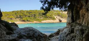 vistas a una playa con gente en el agua en Addaia Coves Noves Playa Arenal d'en Castell en Es Mercadal