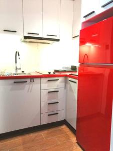 um frigorífico vermelho numa cozinha com armários brancos em Rafina's blue heart! em Rafina