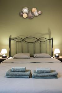 a bed with two towels on it with two lamps at Niochori Heritage: The Pianist Suite in Rhodes Town