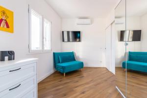um quarto com duas cadeiras azuis e uma janela em Poerio Rooftop Luxury apartament em Nápoles