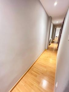 - un couloir avec des murs blancs et du parquet dans l'établissement Apartamento Zaragoza Centro, à Saragosse