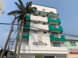 un bâtiment avec un palmier en face dans l'établissement Hotel Suites Regina, à Veracruz