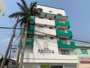 a building with a palm tree in front of it at Hotel Suites Regina in Veracruz