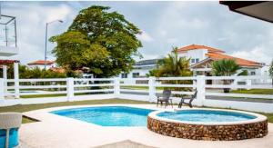 uma piscina num quintal com uma cerca branca em Hermosa Casa de Playa em Nueva Gorgona