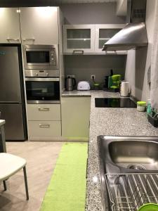 a kitchen with stainless steel appliances and a sink at 2 bedrooms apartement with sea view private pool and enclosed garden at Lombo Do Doutor 1 km away from the beach in Calheta