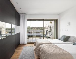 2 bedden in een slaapkamer met uitzicht op een balkon bij Beach Front Dream Penthouse - pool & gym & parking in Herzliyya B