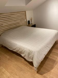 a bedroom with a large bed with a white bedspread at Magnifique grange avec spa / love room in Saint-André-de-Cubzac