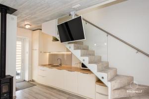 Il comprend une cuisine avec un escalier et une télévision à écran plat. dans l'établissement Grit House, à Palanga