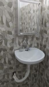 uma casa de banho com um lavatório branco e um espelho. em Espaço interno em Salvador