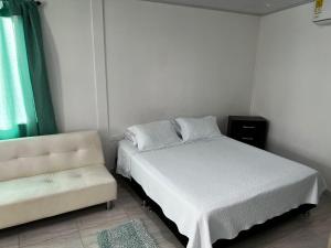 um quarto com uma cama e um sofá em SWEET BREEZE em San Andrés