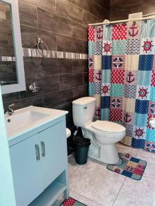 a bathroom with a toilet and a sink and a shower at Orsini Beach Apartment in Aguadilla