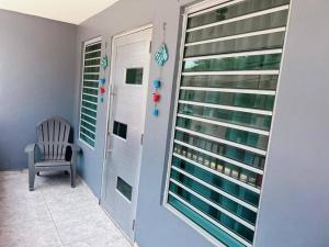 a balcony with a chair and a window with blinds at Orsini Beach Apartment in Aguadilla
