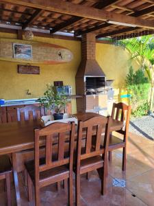 comedor con mesa, sillas y fogones en Suítes Recanto Praia Grande, en Penha