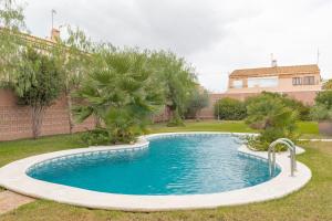 uma piscina num quintal com árvores e uma casa em Anna's garden em Torrevieja