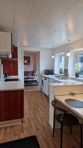 ロービュにあるCity Apartments Rødbyの白いカウンターとテーブル付きのキッチンが備わります。