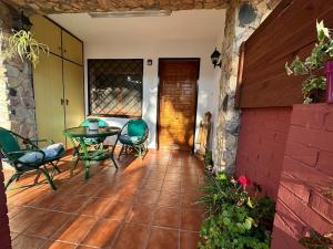eine Terrasse mit einem Tisch, Stühlen und einer Tür in der Unterkunft Apartamento Can Giru in Tordera