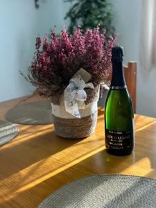 eine Flasche Wein neben einer Blumenvase in der Unterkunft Apartamento Can Giru in Tordera