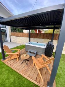 a gazebo with chairs and a hot tub at Magnifique grange avec spa / love room in Saint-André-de-Cubzac
