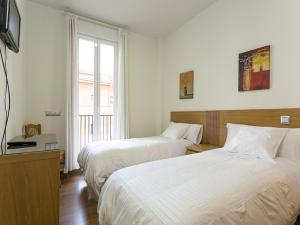a hotel room with two beds and a window at Apartments Center Madrid in Madrid