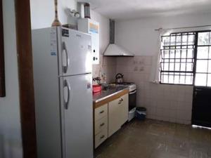 cocina con nevera blanca y fregadero en Encanto Urbano 2 en Villa Carlos Paz