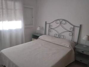 1 cama blanca en un dormitorio con ventana en Encanto Urbano 2 en Villa Carlos Paz