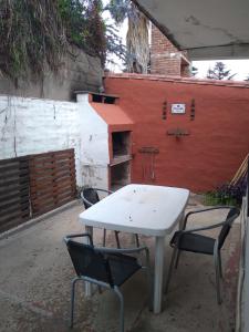 una mesa blanca y dos sillas frente a un edificio en Encanto Urbano 2 en Villa Carlos Paz
