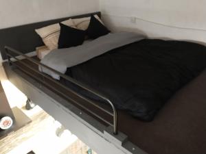 un letto con coperta nera e cuscini sopra di Cozy room a Birżebbuġa