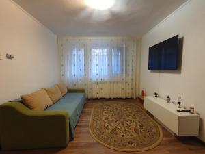a living room with a couch and a tv at ZSE Residence in Constanţa