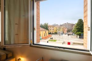 ventana con vistas a una calle de la ciudad en Large studio flat with private car park, en Bolonia