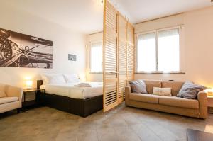 1 dormitorio con 1 cama y 1 sofá en Large studio flat with private car park en Bolonia