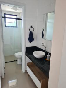 a bathroom with a sink and a toilet at Apartamento novo em Caiobá in Matinhos