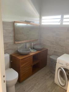 a bathroom with two sinks and a toilet and a mirror at Jolibois Lodge & Spa in Le Gosier