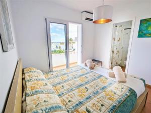 a bedroom with a bed and a large window at Bella Brisa, Port d'Addaia in Port d'Addaia