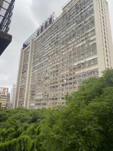 un gran edificio con árboles delante de él en Apart Alameda Santos - Paulista, en São Paulo