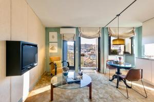 a living room with a television and a table and chairs at Urban Apartment Casa da Portela in Porto