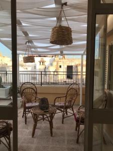 a patio with chairs and tables on a balcony at M&M Palazzotto Maria in Fasano