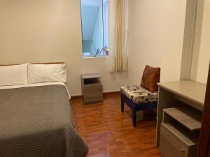 a bedroom with a bed and a chair and a window at Hostal Sotillo in Ilo +31 photos