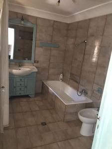 La salle de bains est pourvue d'une baignoire, d'un lavabo et de toilettes. dans l'établissement M&M Palazzotto Maria, à Fasano