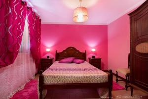 a bedroom with pink walls and a bed with purple pillows at 2 bedrooms apartement with sea view private pool and enclosed garden at Lombo Do Doutor 1 km away from the beach in Calheta